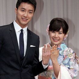 結婚会見で指輪を見せる2人